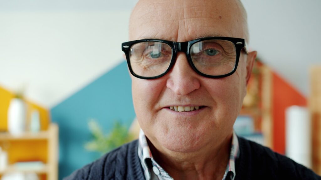 Homem idoso de óculos sorrindo