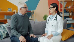Médico conversando com paciente idoso